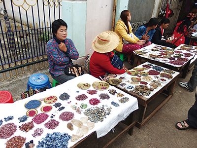 図９–２．路地に机、箱を並べ、宝石を売る女性たちを見ることができる。